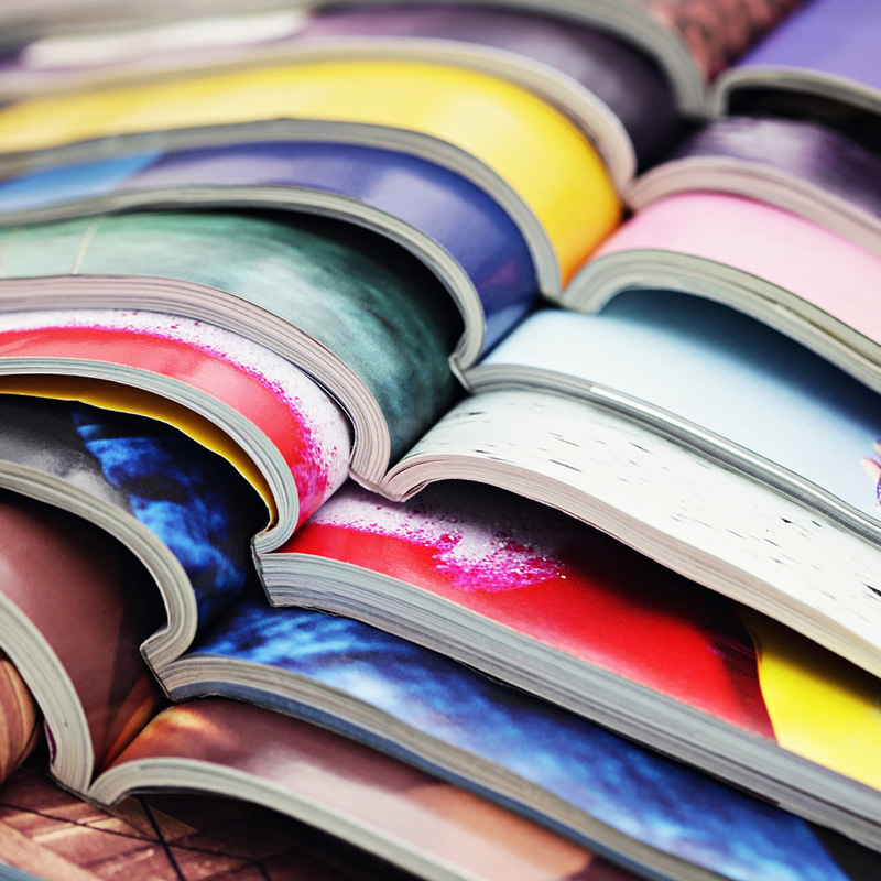 A stack of colourful printed booklets opened on top of each other