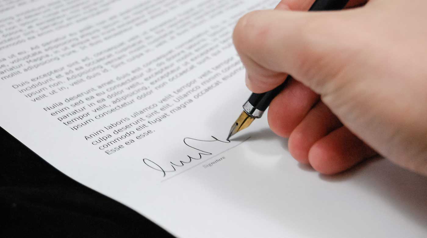 Person signing a legally-binding document with a fountain pen