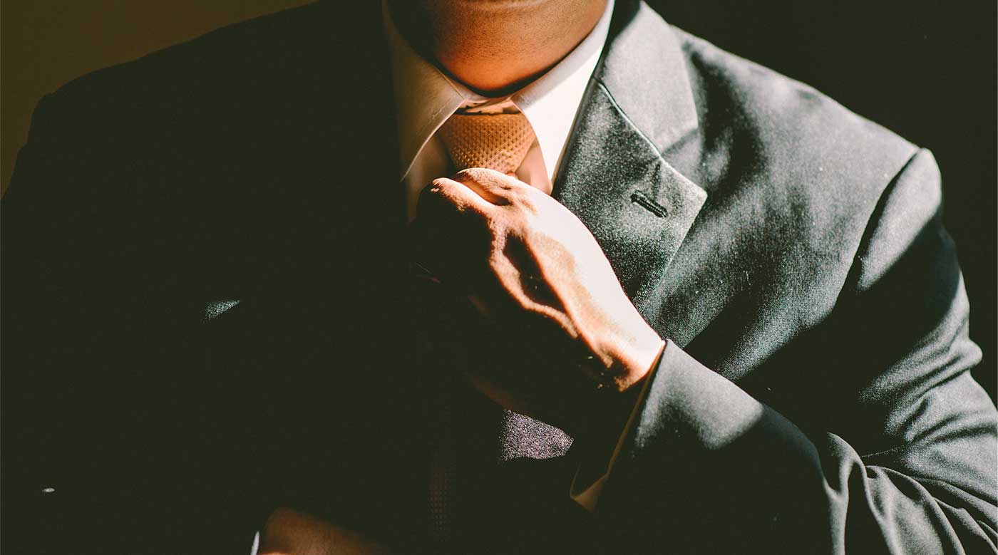 Businessman wearing a suit and tightening his tie