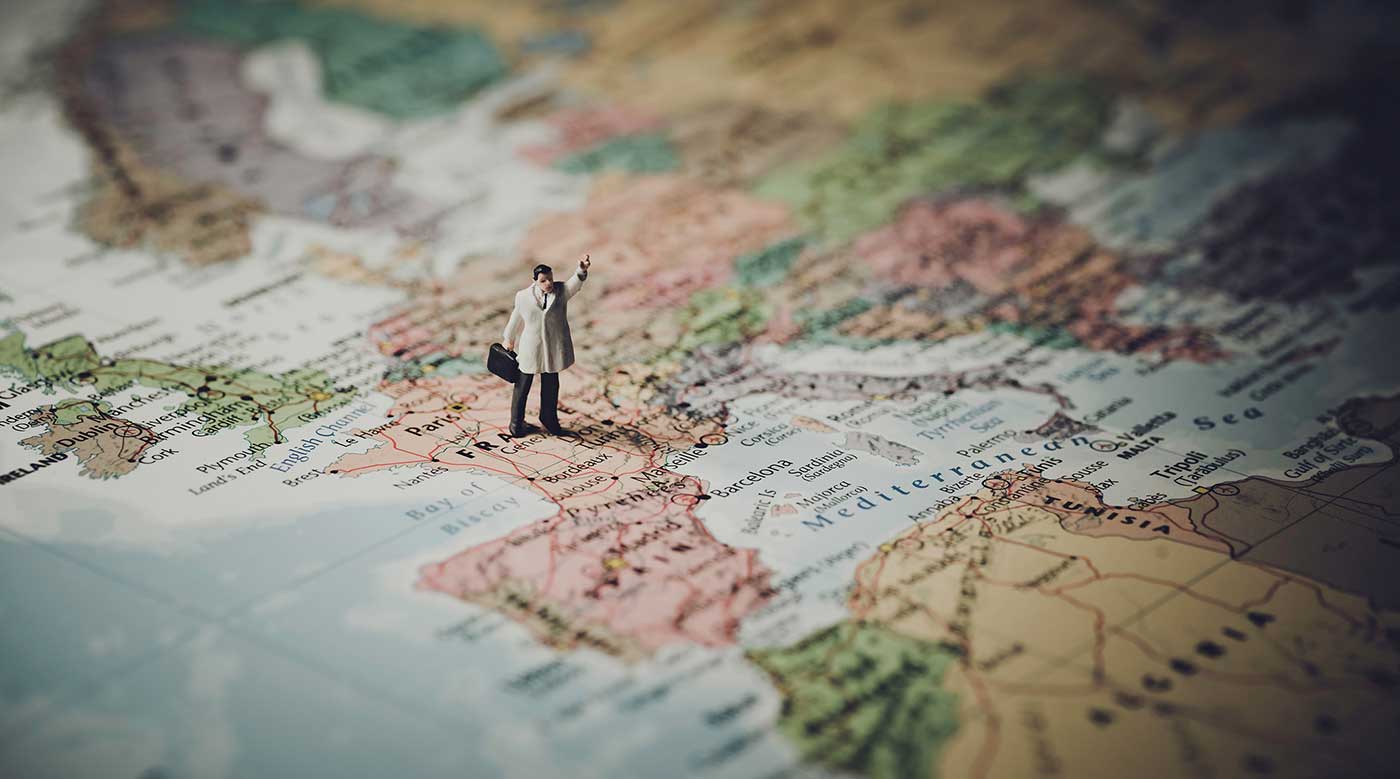 Miniature figurine of a map standing on a map of the Europe