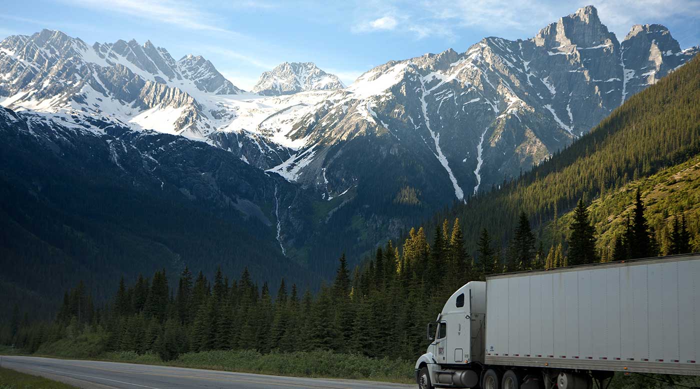 Freight truck transporting cargo through snow-capped mountains