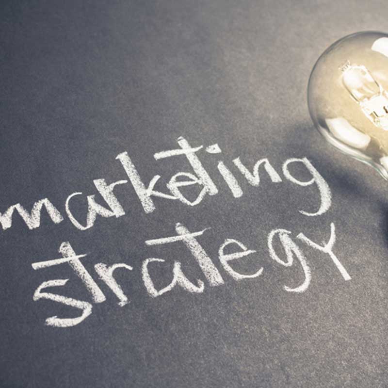 'Marketing strategies' written in chalk next to a light bulb