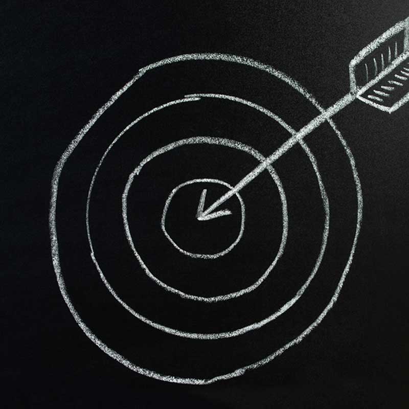Chalk drawing of an arrow hitting the bulls-eye of a target